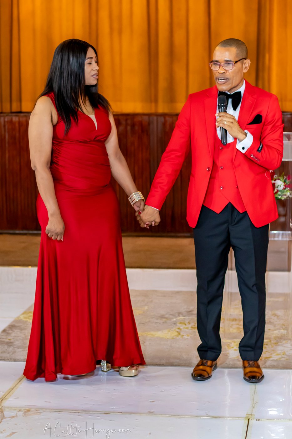 Pastor Phatudi Molapo speaking while holding hands with a woman in red